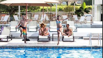 A pool area with lounge chairs and umbrellas.