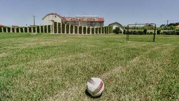 A soccer field with a goalpost and a building in the background.