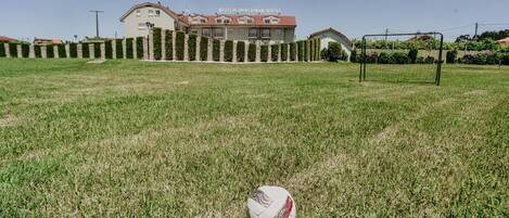 Un campo de fútbol con un arco y un edificio al fondo.