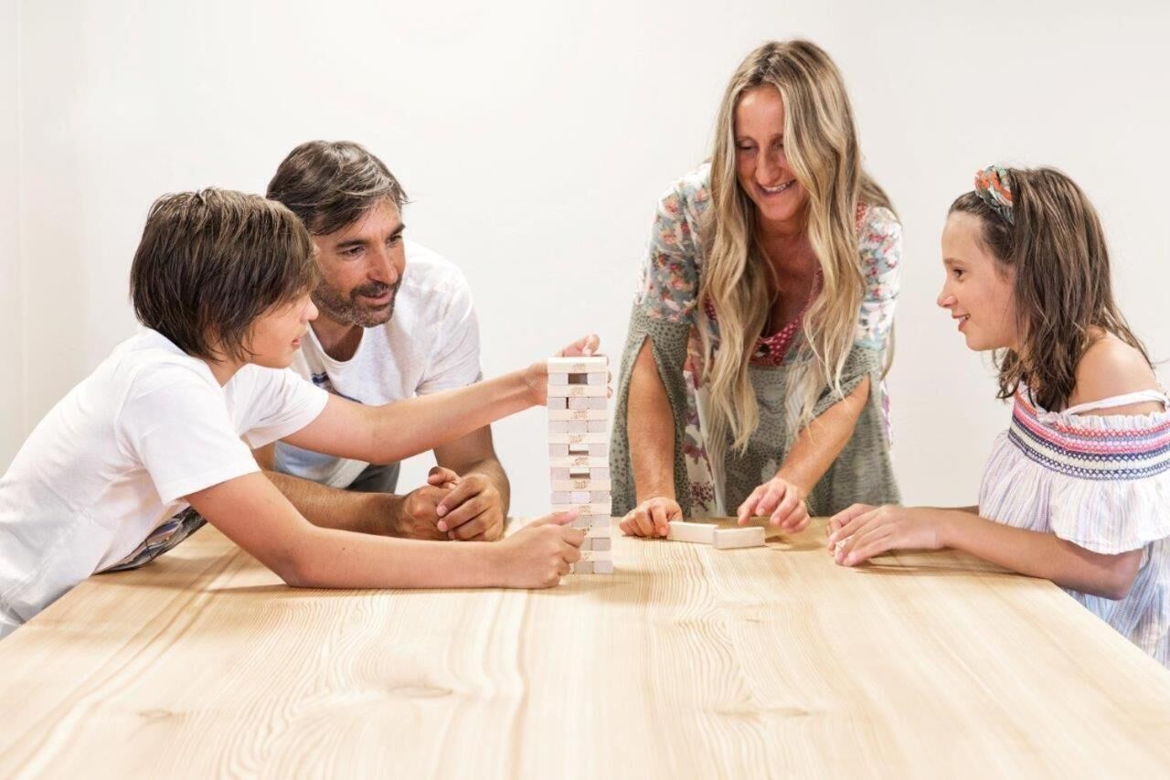 A family playing a board game at a wooden table.