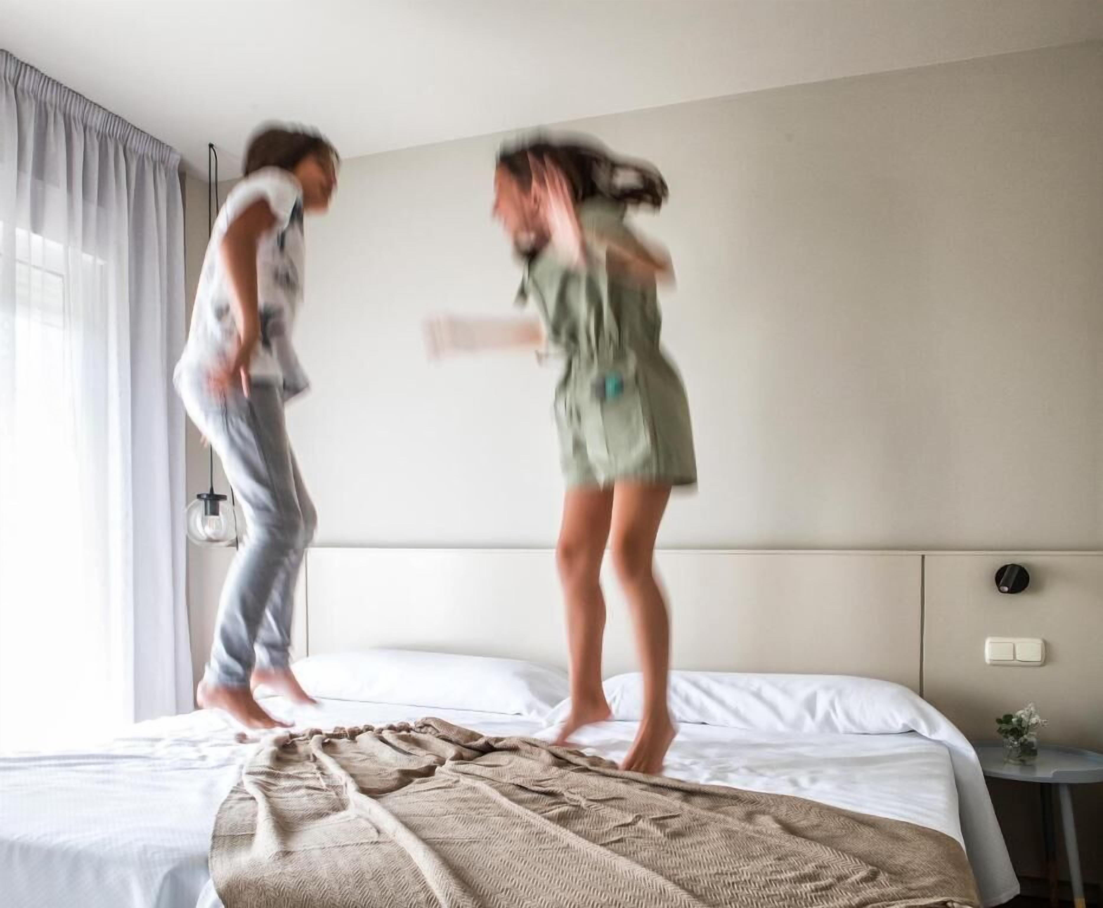 Ein Zimmer mit einem Bett, einem Nachttisch und einem Vorhangfenster.