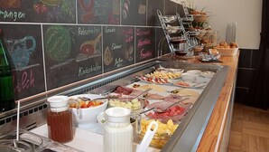 A buffet with various food items and a chalkboard menu listing dishes like 'Rohschinken' and 'Gouda'. - Hotel Winzerhaus Gaertner an der Loreley (Sankt Goar)