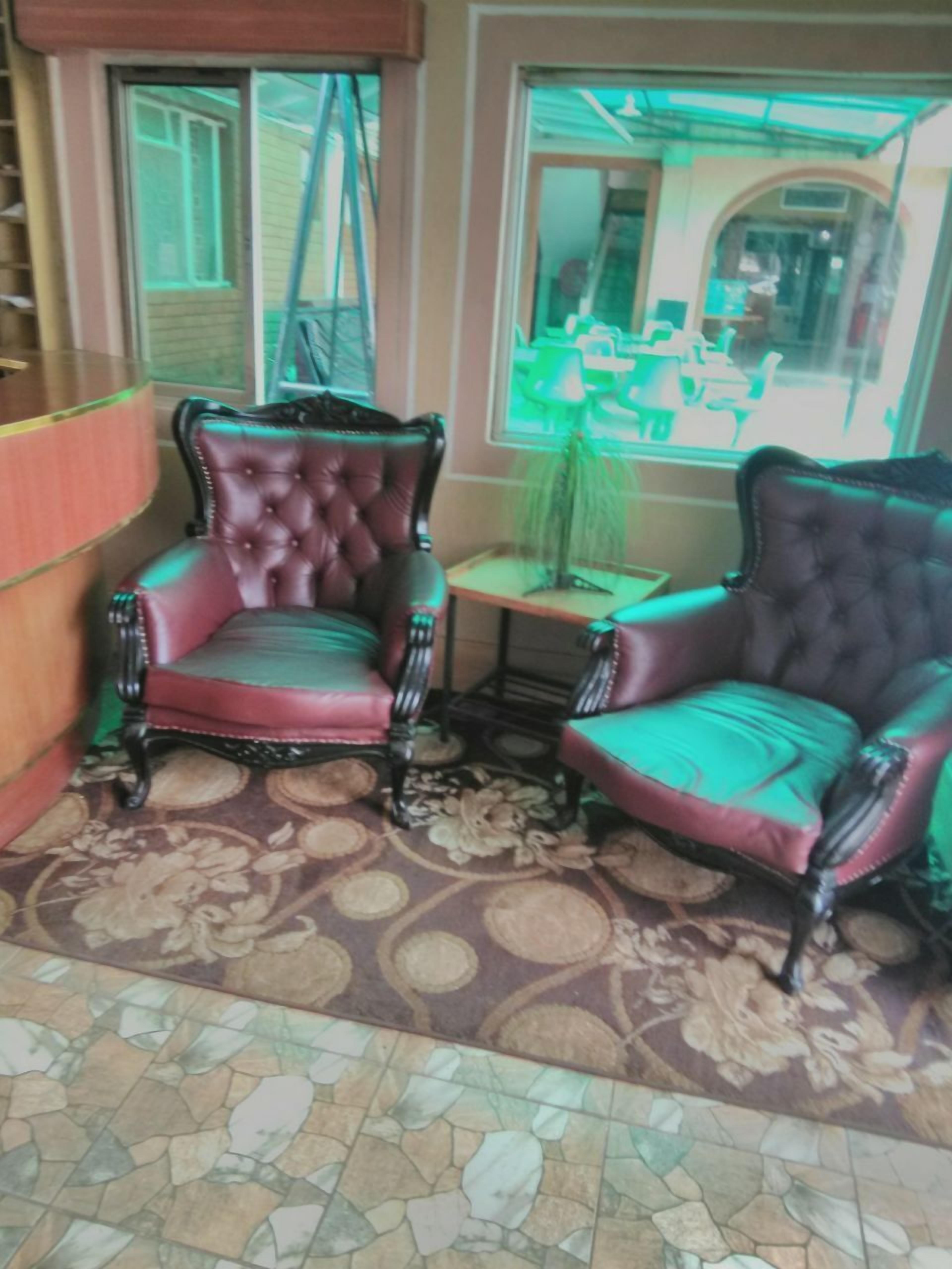 A room with two leather armchairs, a small table, and a patterned floor.
