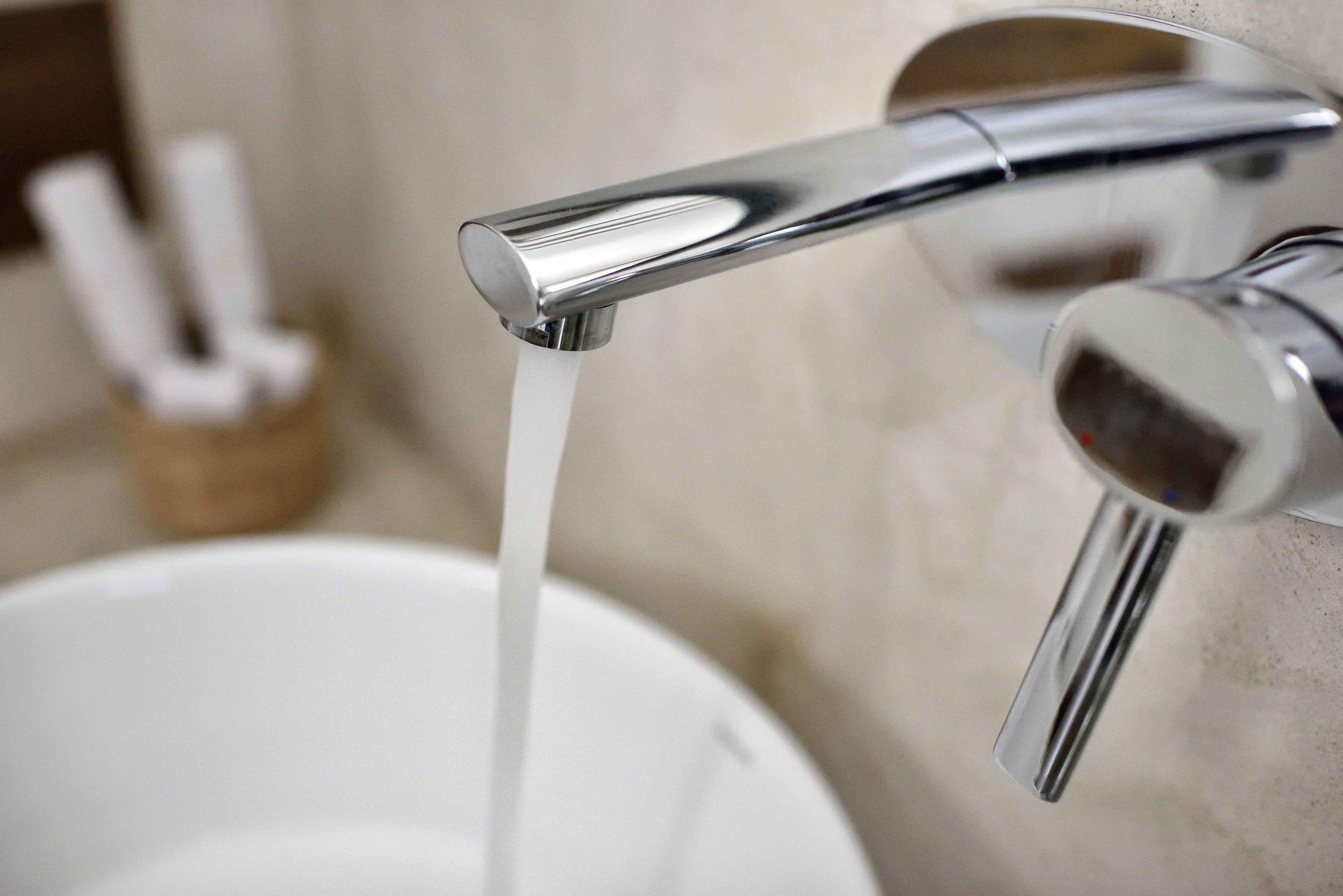 A modern bathroom with a chrome faucet and a white sink.