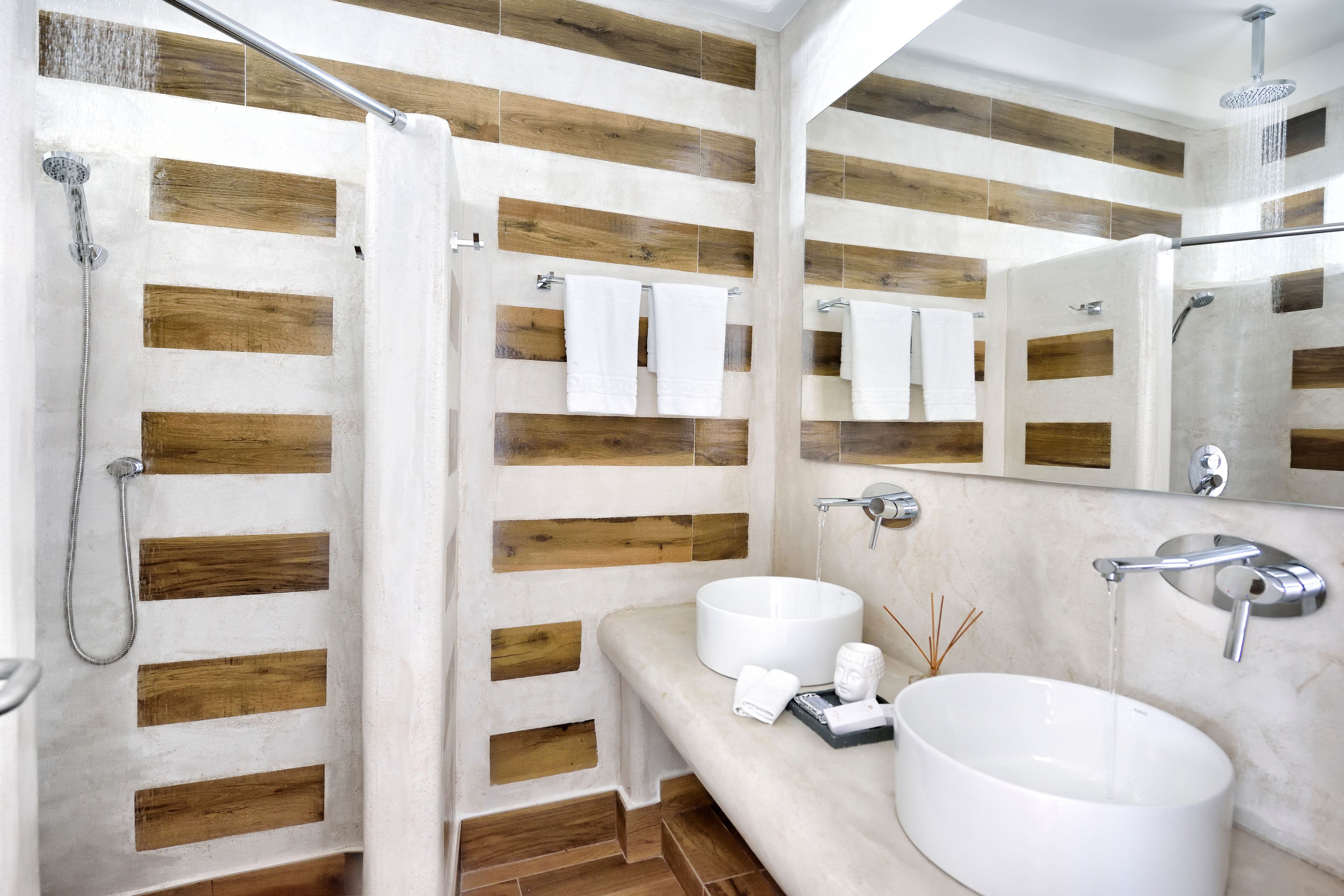 Un baño moderno con paneles de madera, un lavamanos grande y redondo, y una zona de ducha.