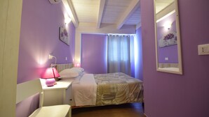 Une chambre à coucher comprenant un lit, un bureau, une chaise, un miroir et un appareil de climatisation.