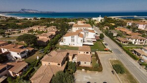 Zona residencial com casas, uma estrada e uma praia ao fundo.