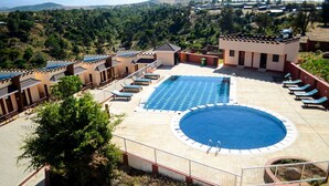 A rooftop pool area with multiple lounge chairs and a large central pool. - Regency Mount Kenya Hotel (Ethi)