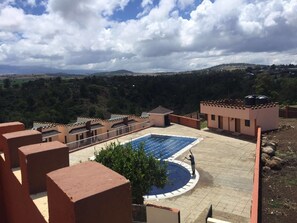 Una piscina al aire libre, sombrillas, tumbonas