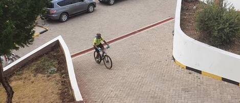 A parking area with multiple cars and a cyclist.