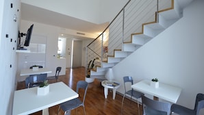 A modern interior with a staircase, dining area, and kitchen. - White (Porto Cesareo)