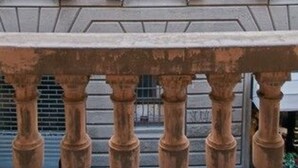 A building facade with multiple windows, some with shutters, and a balcony railing in the foreground. - Residenza dei Pucci (Florence)