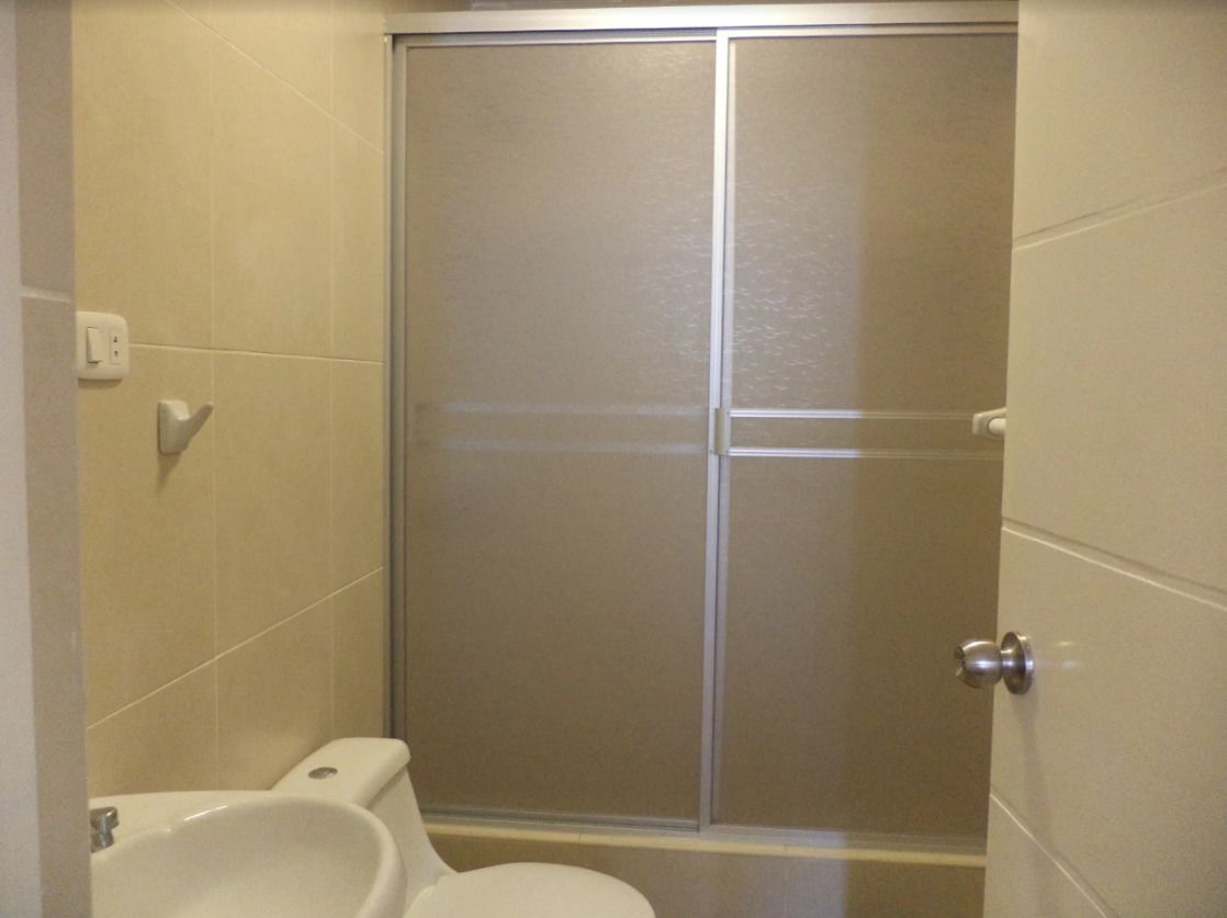 A bathroom with a toilet, a bidet, and a shower stall.