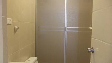 A bathroom with a toilet, a bidet, and a shower stall.