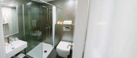 Ein modernes Badezimmer mit einer Duschkabine aus Glas, einem weißen Waschbecken und einer Toilette.
