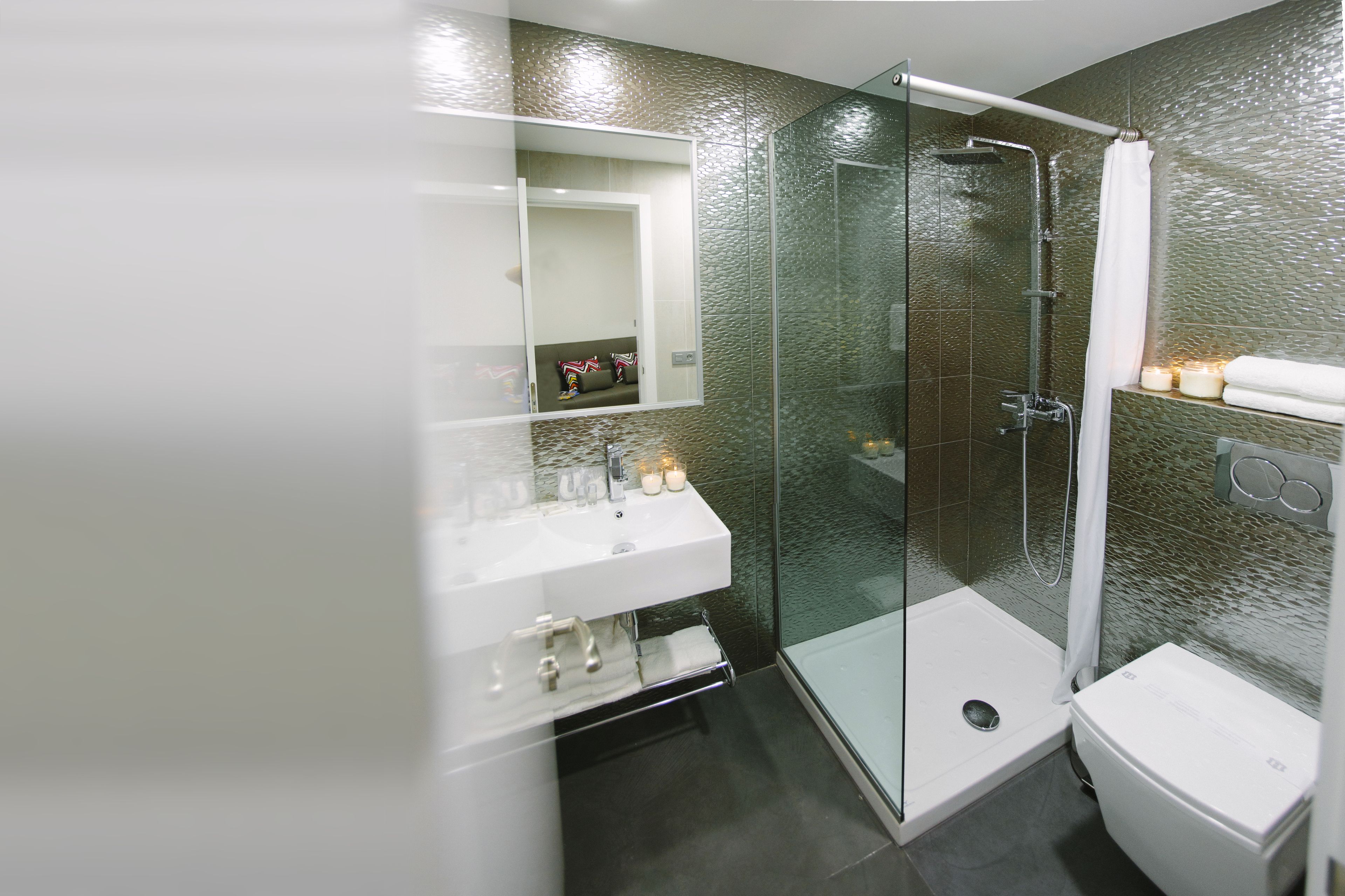A modern bathroom with a glass-enclosed shower, a white sink, and a glass shower door.