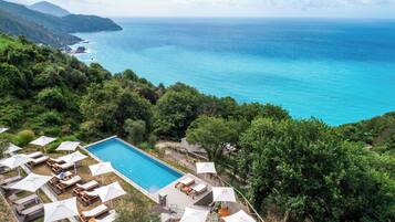 Outdoor pool, an infinity pool, pool umbrellas, sun loungers