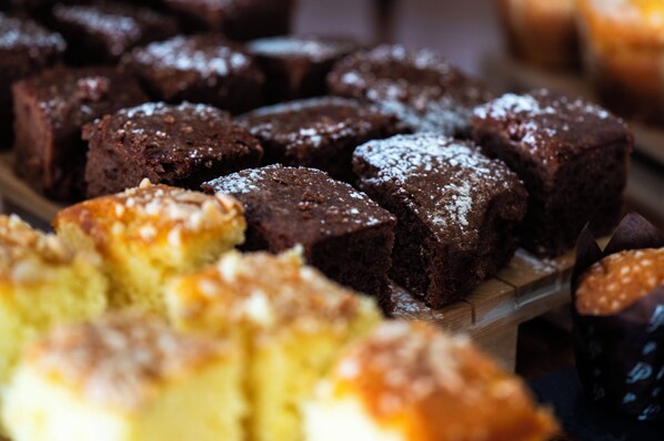Diversas opciones de productos horneados, como brownies y un pastel amarillo, sobre una superficie de madera.