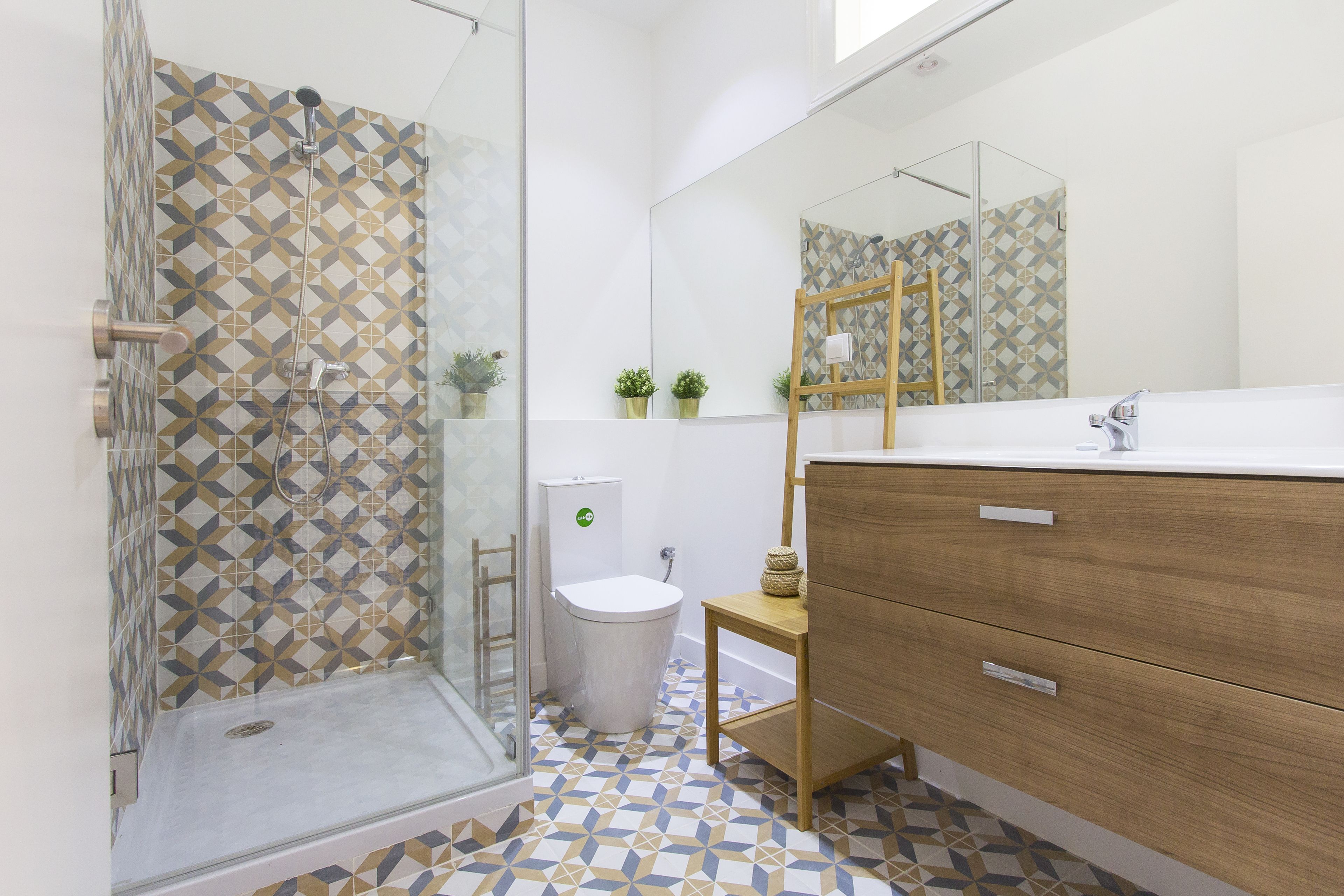 Un baño con ducha, inodoro y tocador.