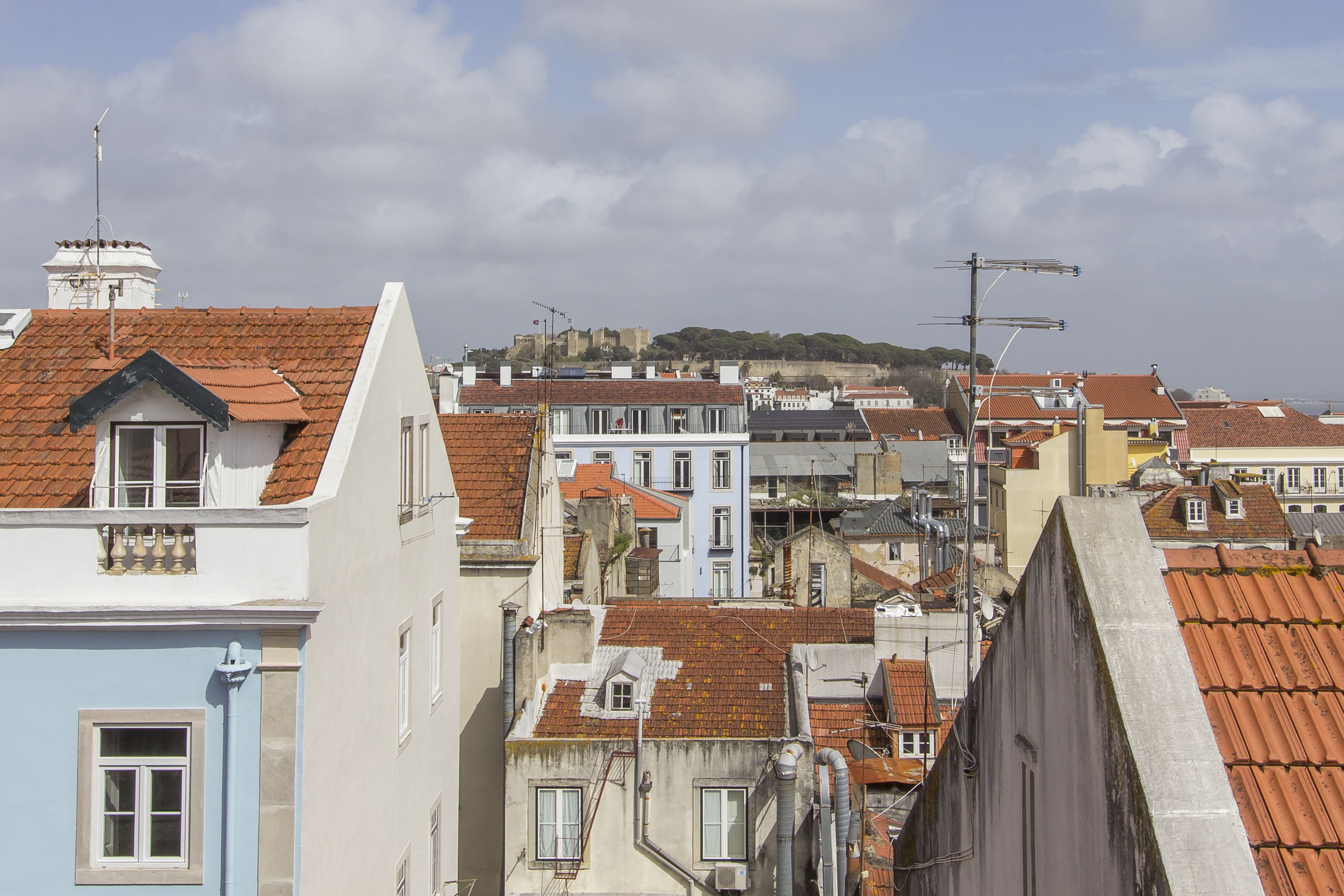 A densely packed urban area with buildings featuring red-tiled roofs and a variety of architectural styles.