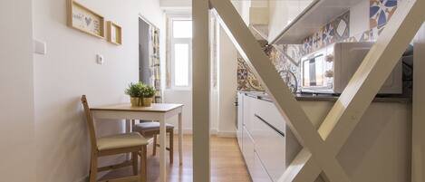 A modern kitchen with a built-in oven and a window overlooking the garden.