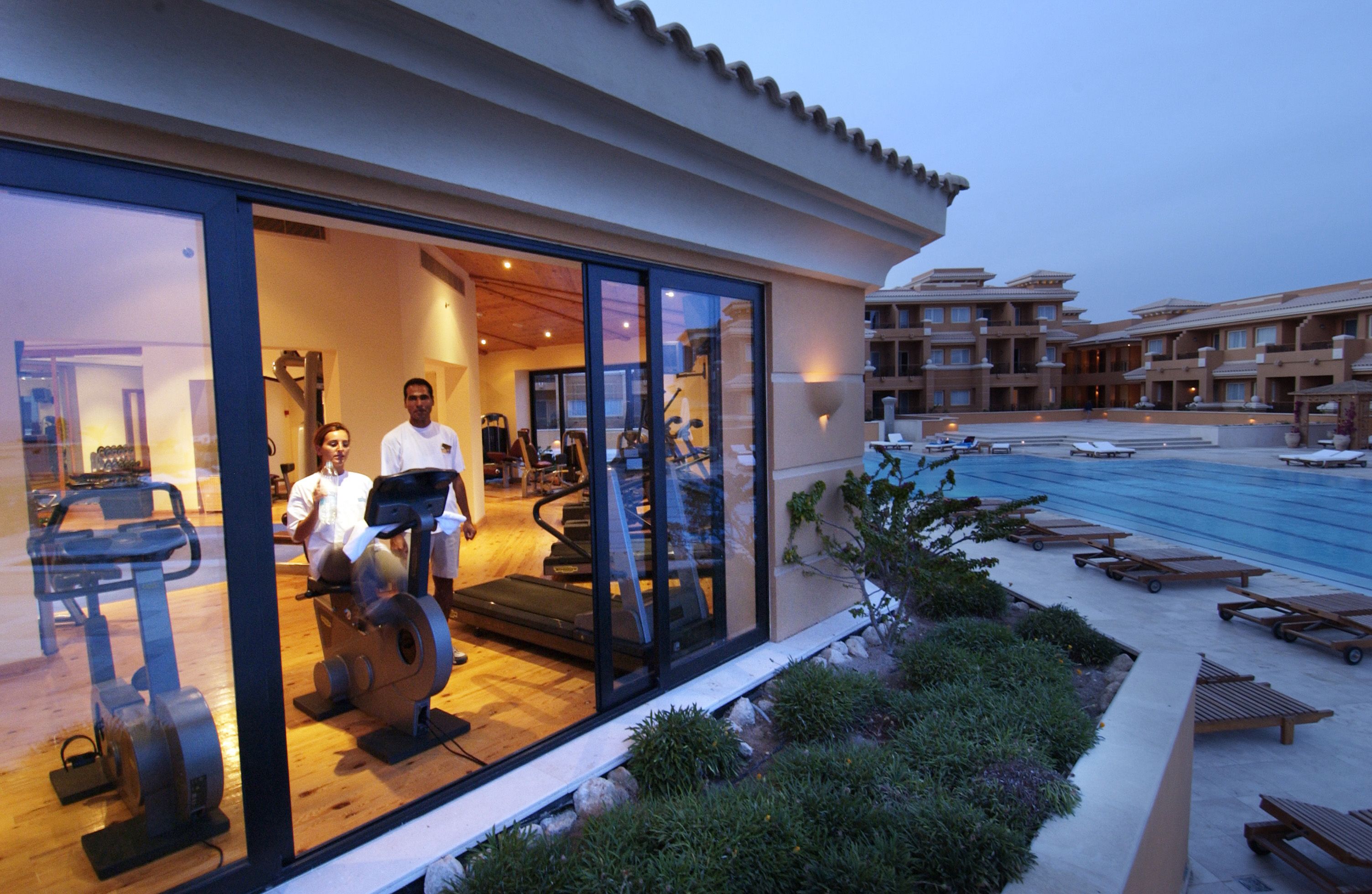 Un hotel con palestra, piscina esterna e area lounge.
