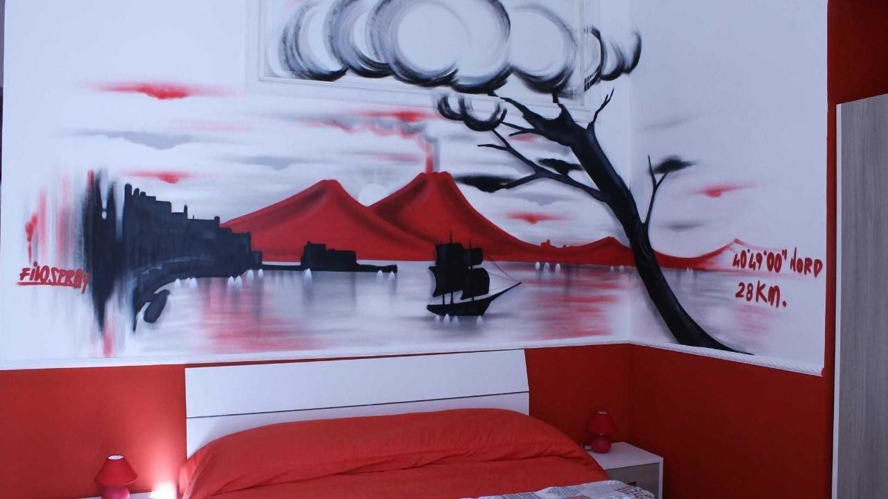 Une chambre à coucher ornée d’une fresque représentant une montagne et un arbre.