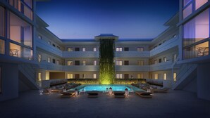 A modern hotel with a central pool, multiple balconies, and a waterfall feature. - Beach Haus Key Biscayne (Key Biscayne)