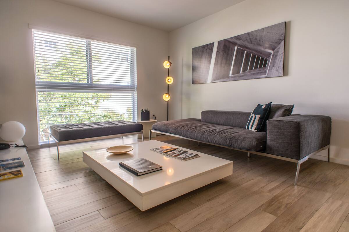 A modern living room with a sofa, a coffee table, and a floor lamp.