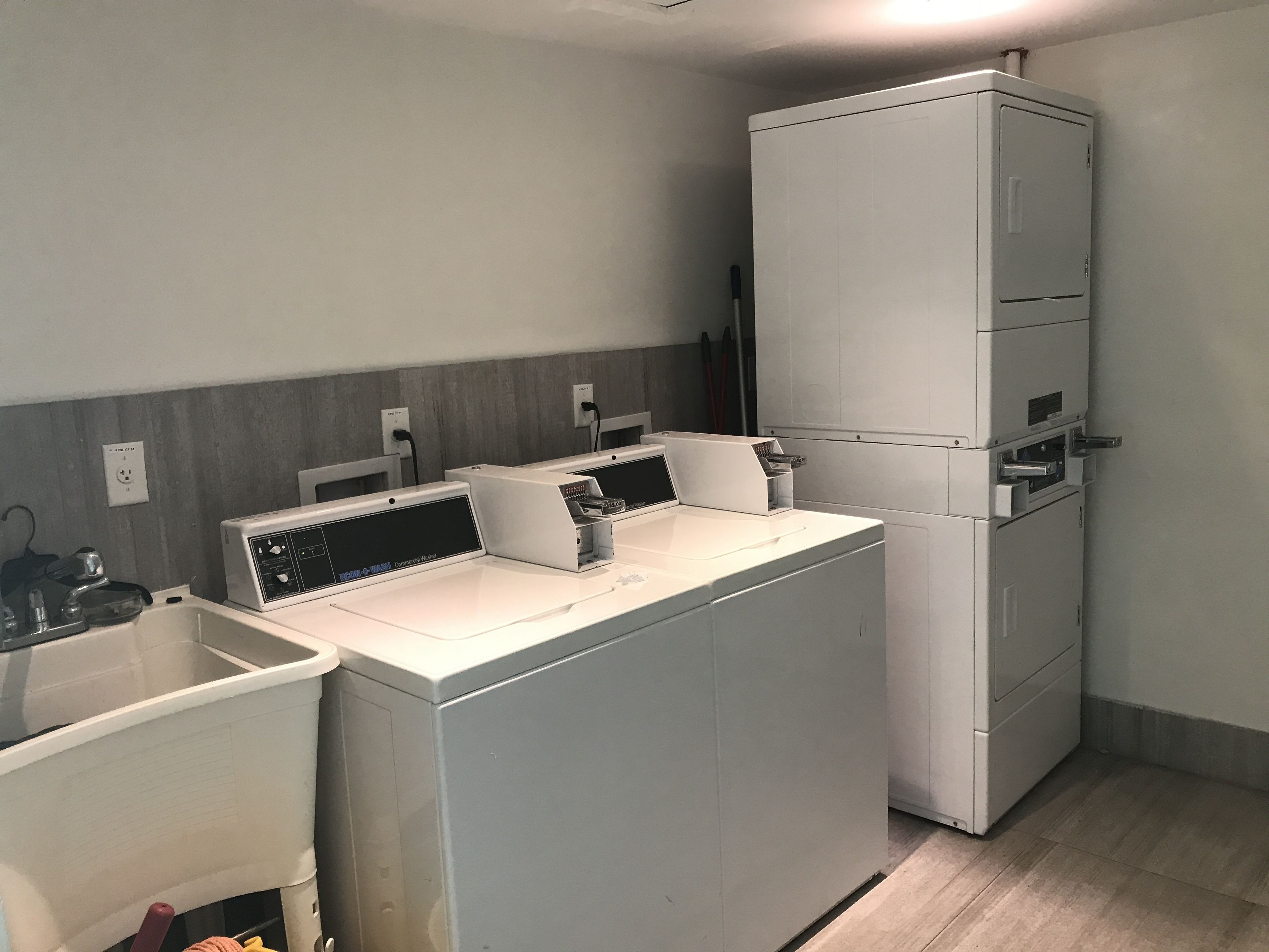A compact kitchen with a washing machine, a small sink, and a countertop.