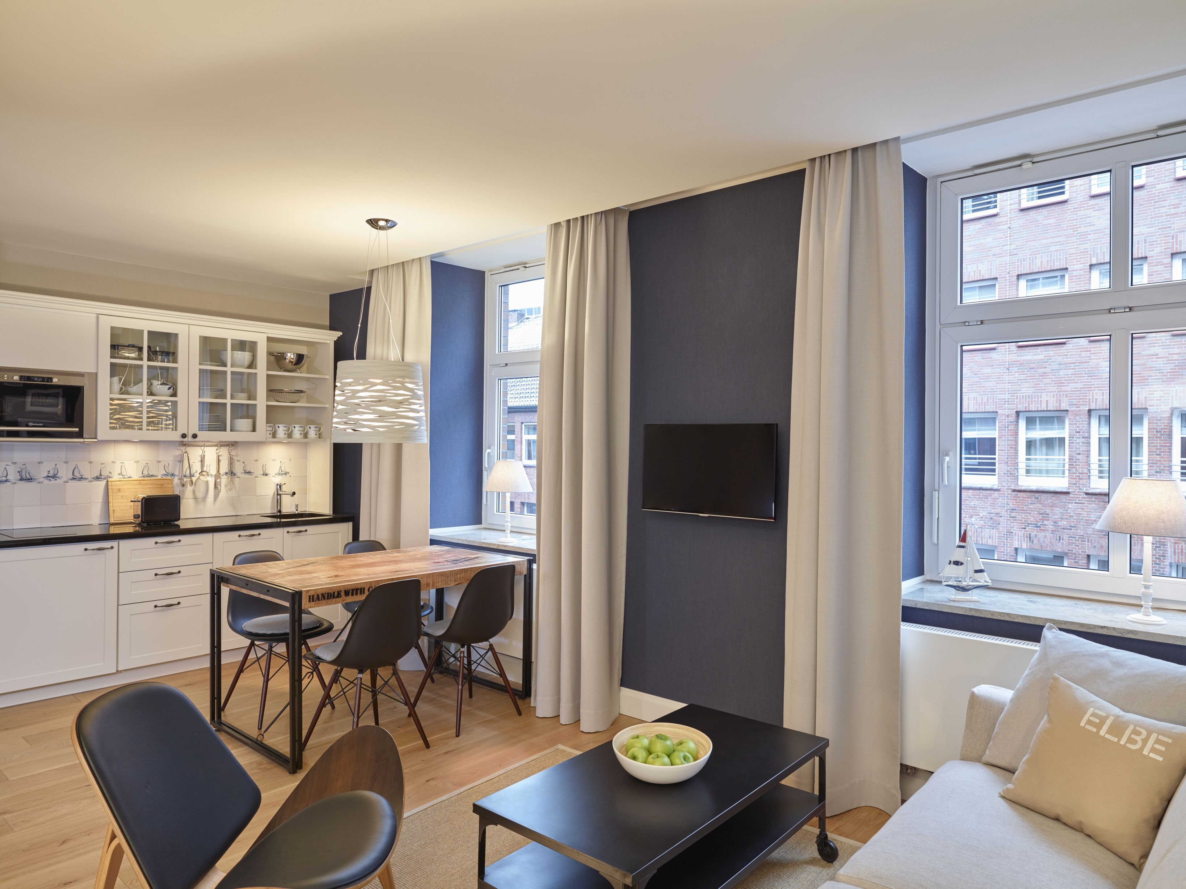 A modern apartment with a kitchen, dining area, and living room.