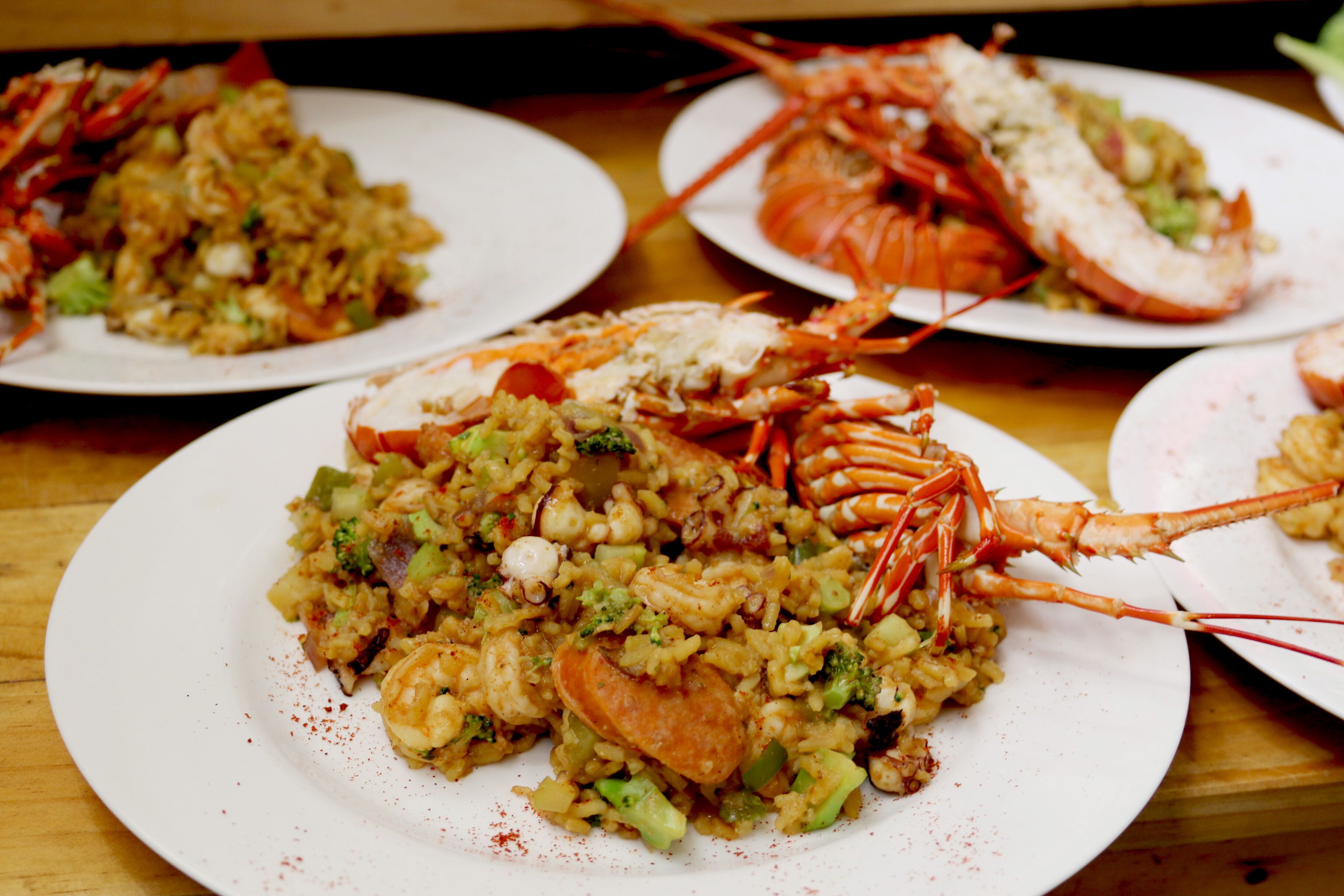 Una mesa de comedor con platos de mariscos y arroces.