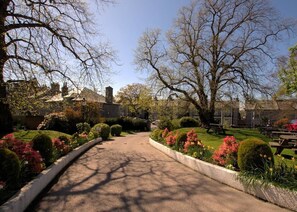 A pathway leading to a building with a garden and picnic tables. - The Ferryhill House Hotel (Aberdeen)