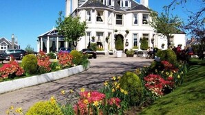 A large, white, two-story building with a symmetrical facade, multiple chimneys, and a central entrance with a portico. - The Ferryhill House Hotel (Aberdeen)