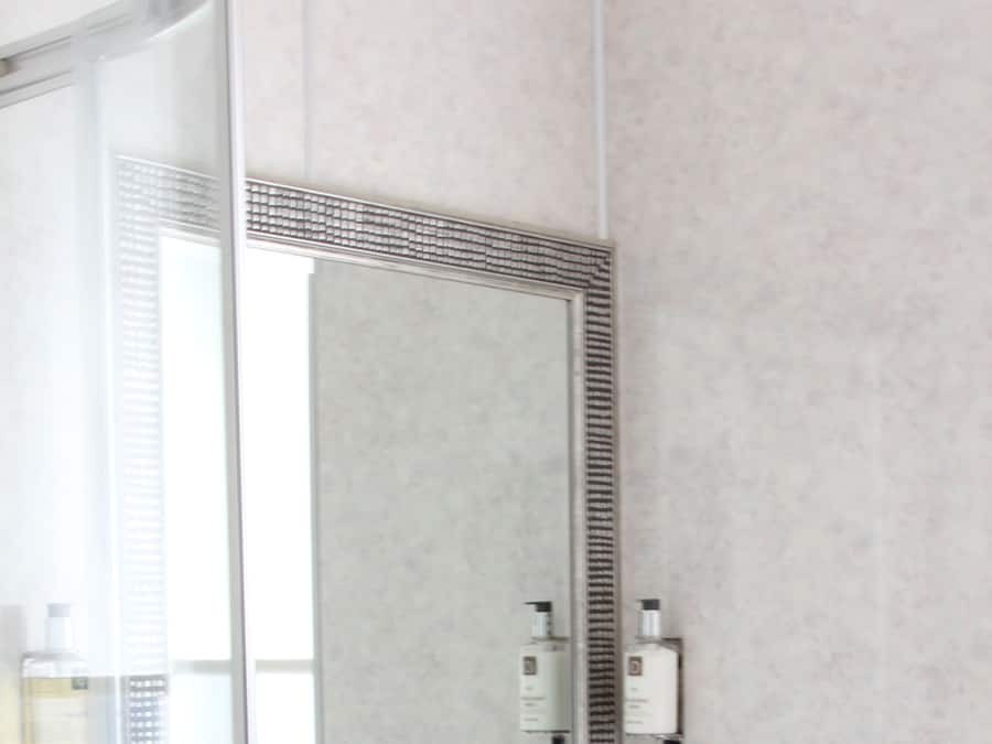 A bathroom with a white sink, a large mirror, and a glass shower enclosure.