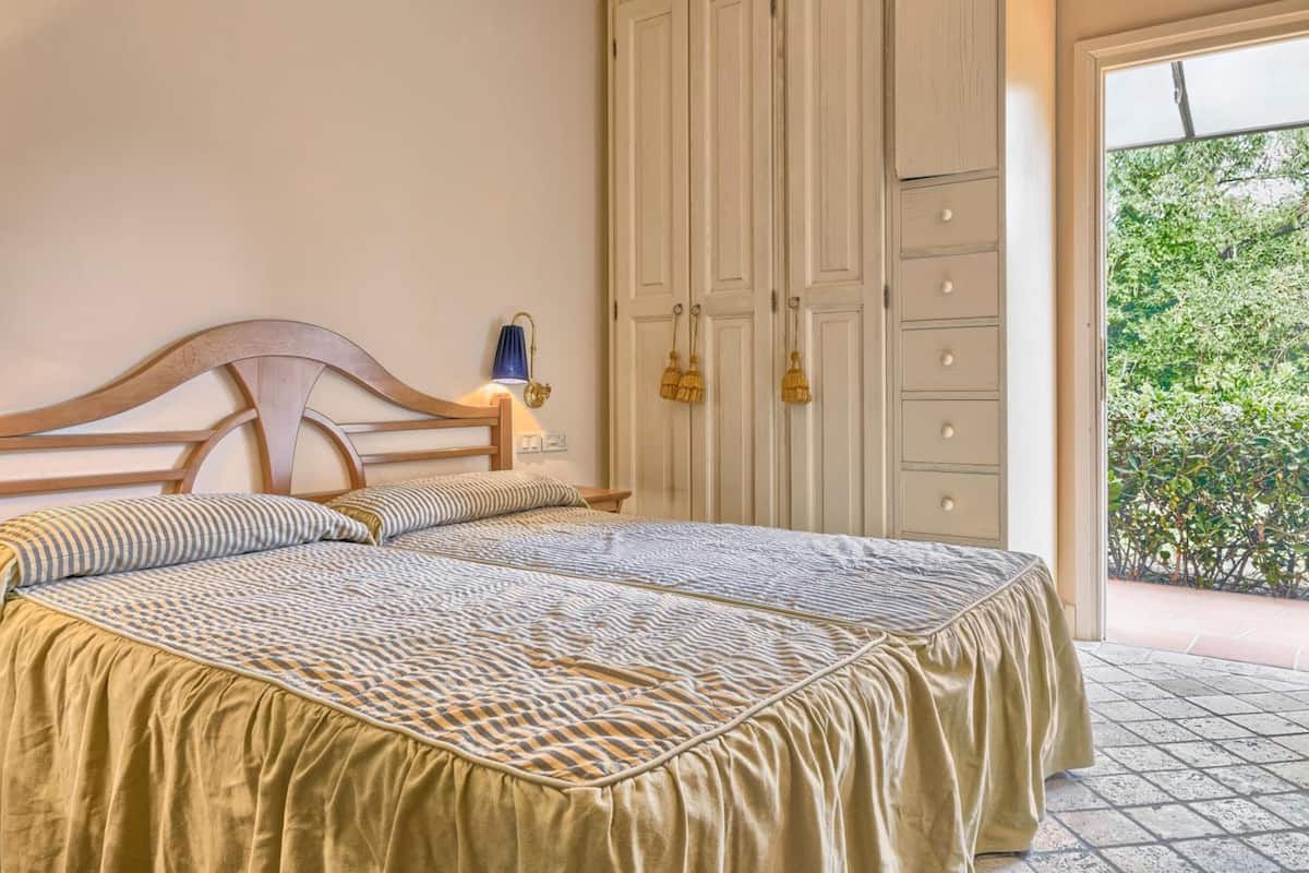 Une chambre à coucher avec un lit, une table de chevet, une lampe et une armoire.