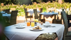 A table set for breakfast with a white tablecloth, plates, cups, and glasses of orange juice. - Roccamare Resort - Hotel Casa di Levante (Castiglione della Pescaia)