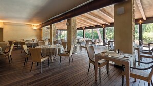 An indoor dining area with wooden flooring, tables, and wicker chairs. - Roccamare Resort - Hotel Casa di Ponente (Castiglione della Pescaia)