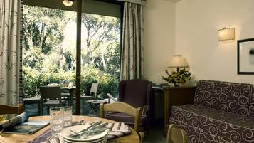 A dining area with a table set for four, a sofa, and a chair.