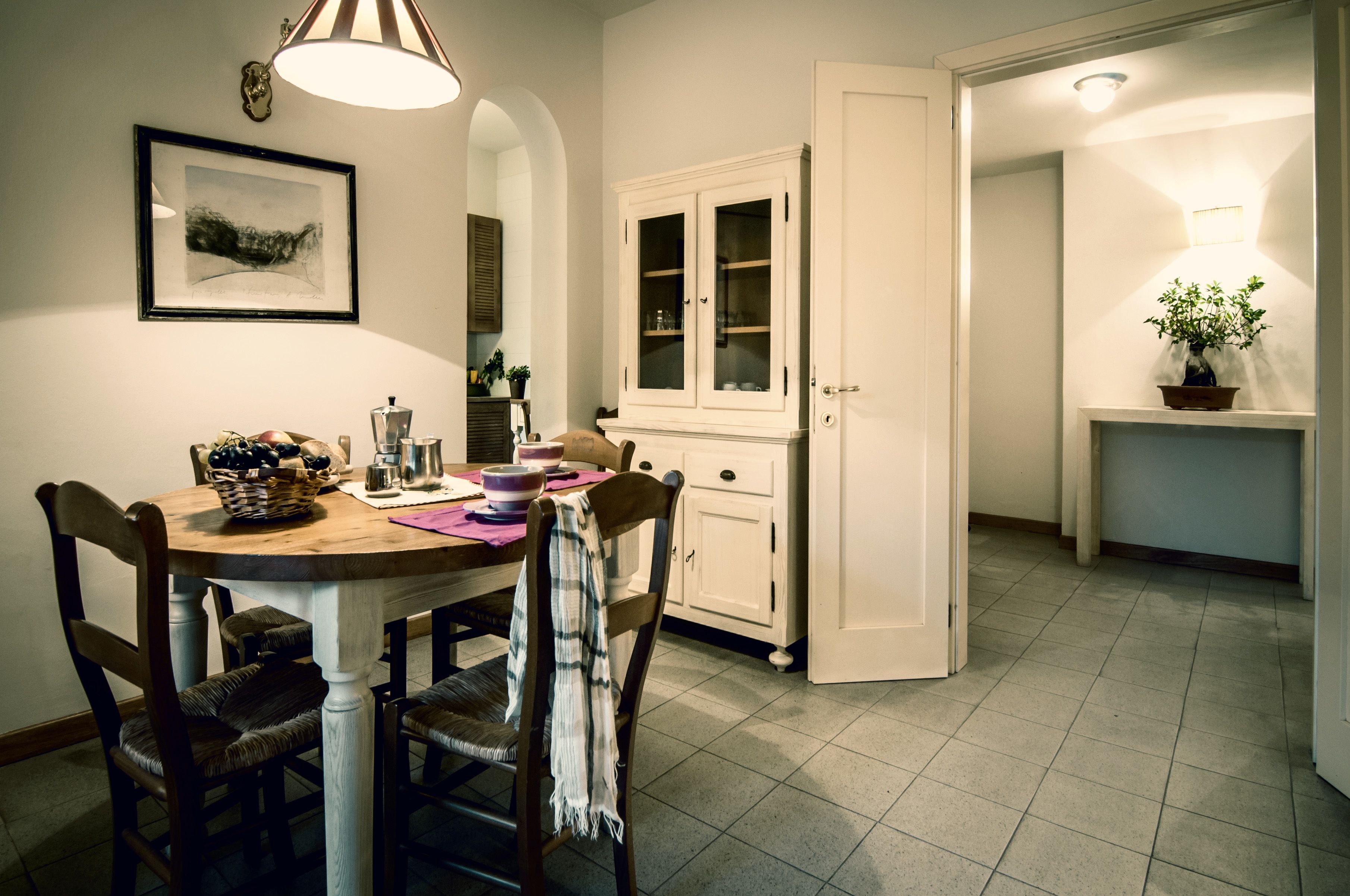 A dining area with a wooden table, chairs, and a cabinet.