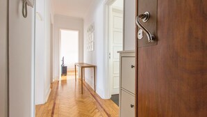Ein Flur mit Holzdielen, einem Tisch und einer Tür mit einem Metallgriff.