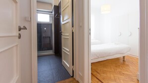 Ein Hotelzimmer mit einem Bett, einem kleinen Fenster und einer Tür zu einem Badezimmer.