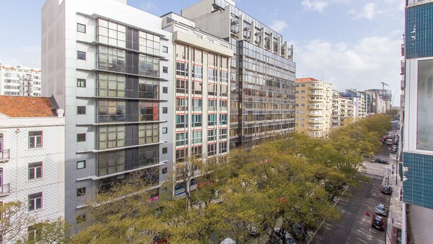 Ein mehrstöckiges Gebäude mit modernem architektonischen Design, das große Fenster und eine Kombination aus Glas- und Betonfassaden aufweist.