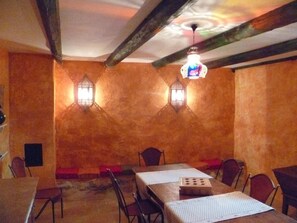 A dining area with a long table, chairs, and a chandelier. - Mas du Puits d'Amour (Orange)
