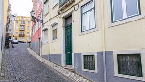 Una estrecha calle adoquinada bordeada por edificios con balcones y ventanas.