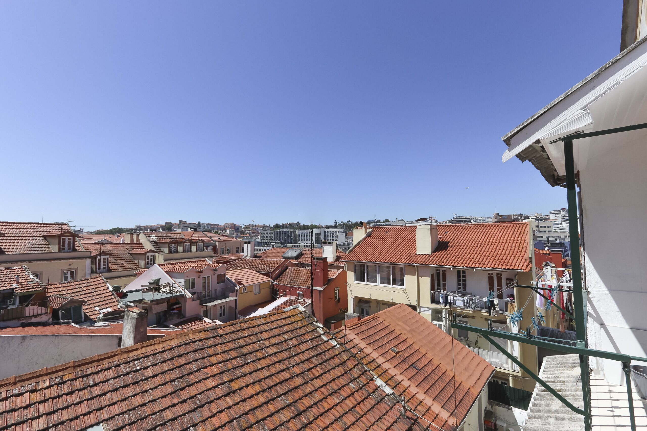A view of terracotta-tiled rooftops in a densely built urban area.