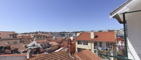 A view of terracotta-tiled rooftops in a densely built urban area.