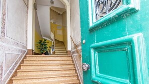 Una escalera que lleva a una puerta con manija metálica y cerradura.