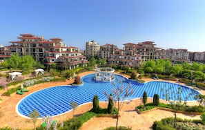 A residential building complex with a central swimming pool, surrounded by greenery and a gazebo. - Apartments in Complex Poseidon (Nessebar)