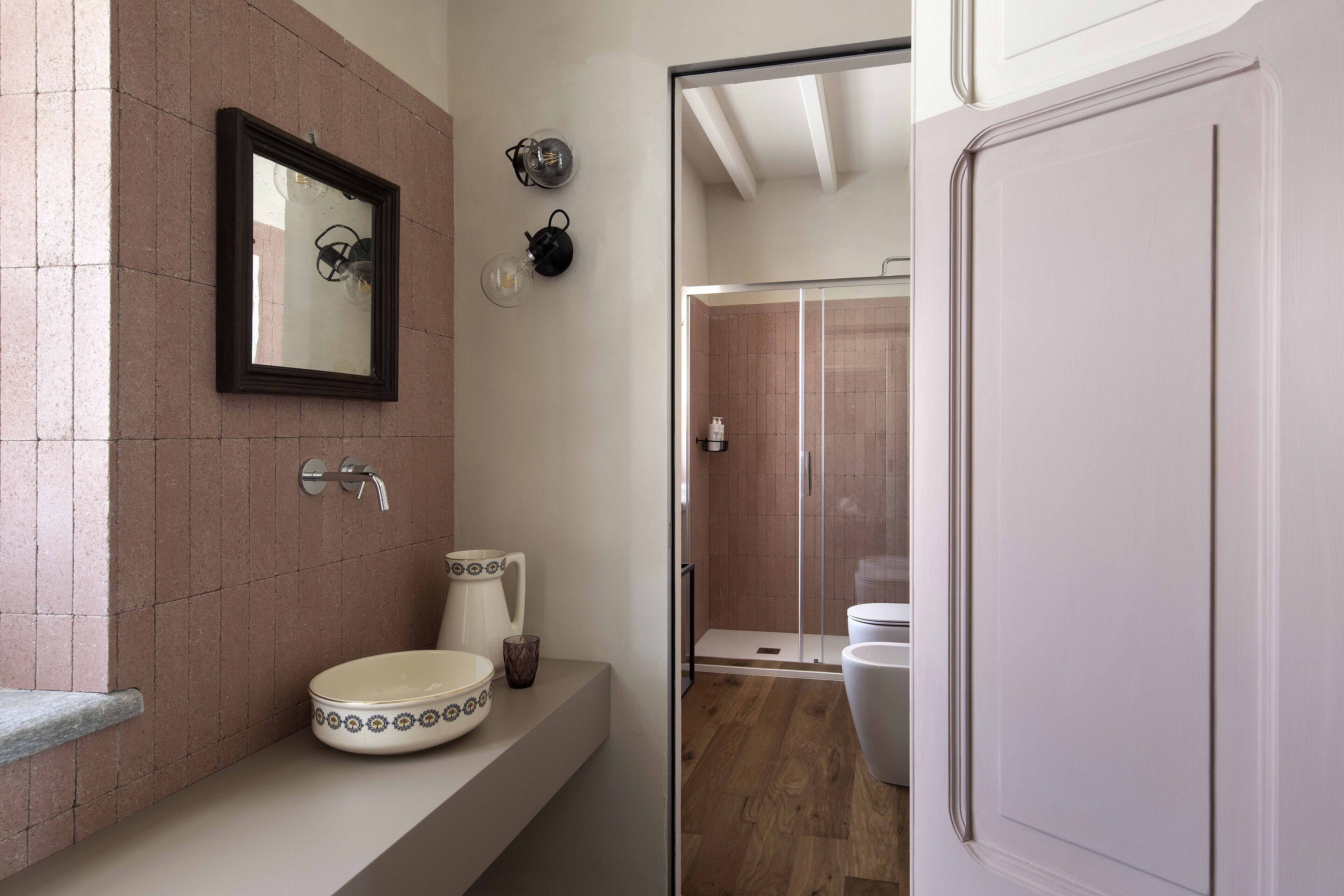 A bathroom with a sink, mirror, and shower.